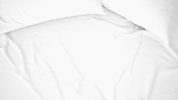 Background of white bed sheet and pillows, top view