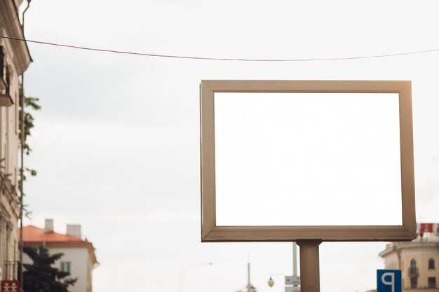 Bilbard with multi-colored advertising and illumination stands on the street in daylight, photo below