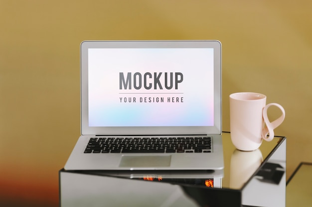 Blank laptop screen and a pink coffee cup