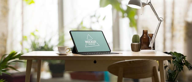 Botanic working room with tablet standing on wood table surrounded by house plants tablet mockup