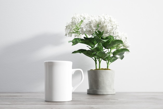 ceramic mug and flower inside flowerpot