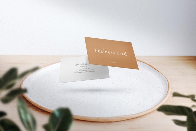 Clean minimal business card mock up floating on a dinning plate with leaves