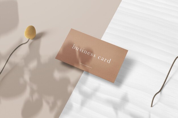 Clean minimal business card mockup on white wood with flowers