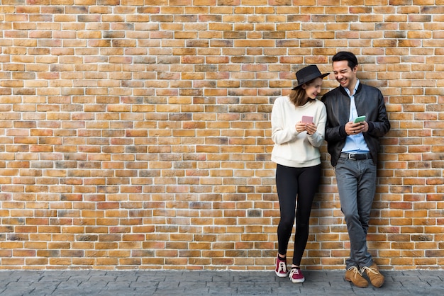 couple dating in front of brick wall