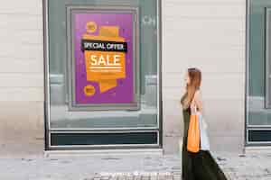 Free PSD design of mock up with sales poster and woman in the street