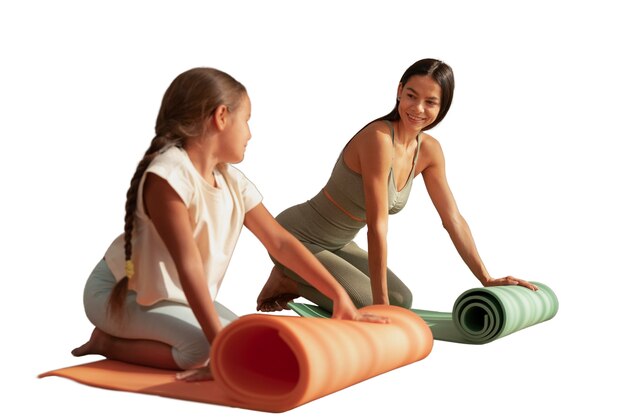 female yoga instructor doing meditation with young girl