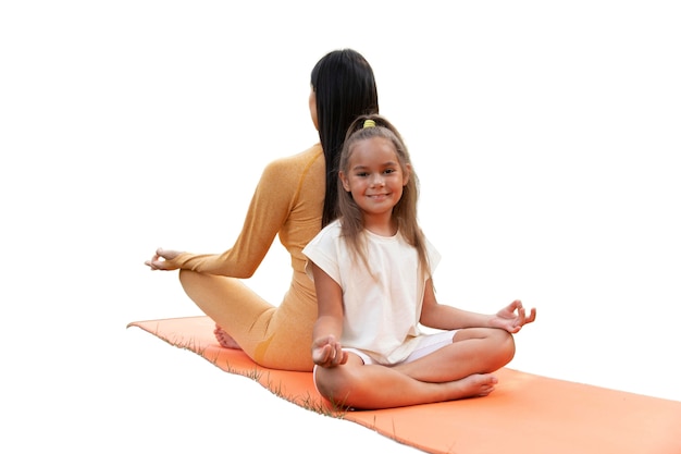 female yoga instructor doing meditation with young girl