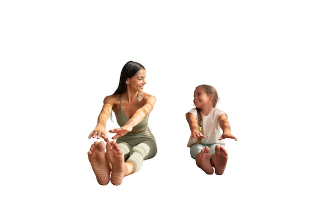 Female yoga instructor doing meditation with young girl