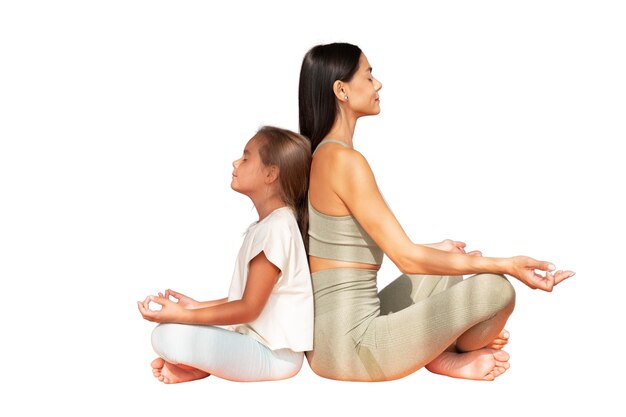 female yoga instructor doing meditation with young girl