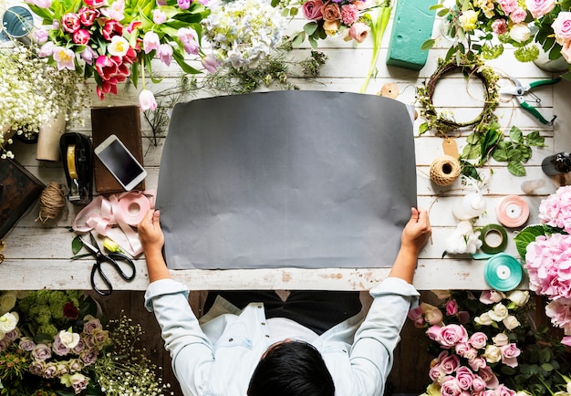 Free PSD florist showing empty design space paper on wooden table