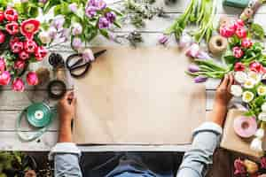 Free PSD florist showing empty design space paper on wooden tablee