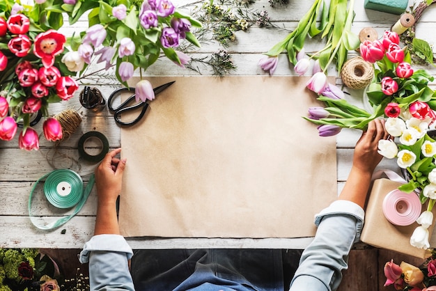 Florist Showing Empty Design Space Paper on Wooden Tablee