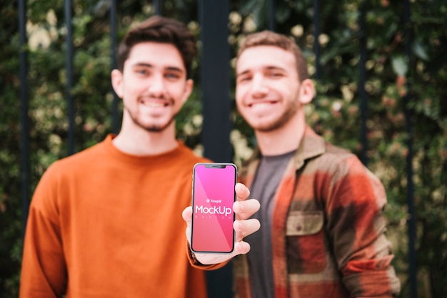 Front view guys holding up smartphone