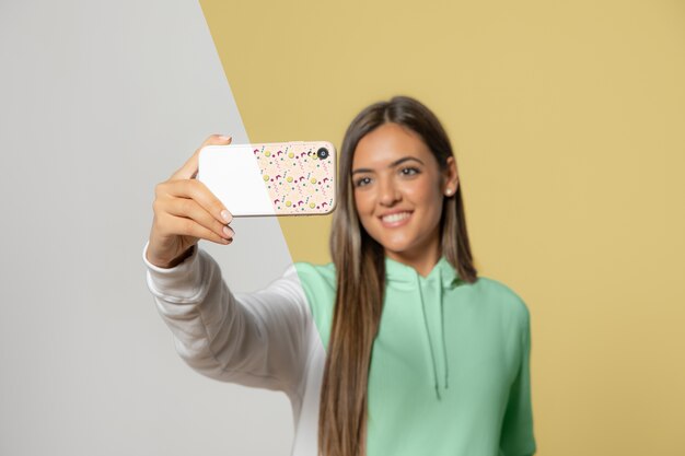 Download Front view of woman in hoodie taking selfie with ...