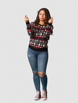 身体​の​若い​女性​が​必要な​身振り​を​している​クリスマス​ジャージー​を​着て