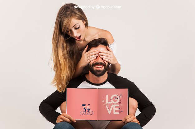 Funny couple holding open book