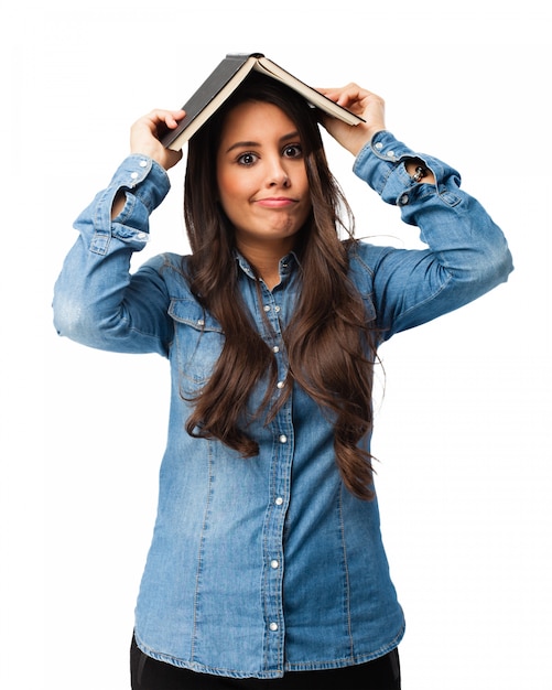 Funny girl covering her head with book