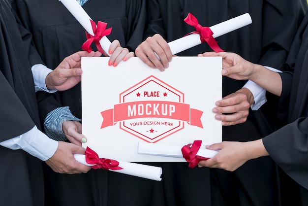 Graduates holding a mock-up diploma