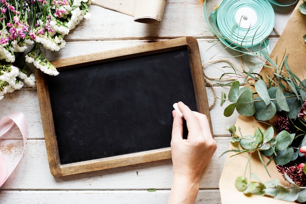 Hand holding chalk and writing on slate