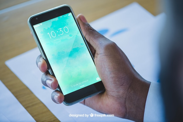 Hand holding smartphone in office