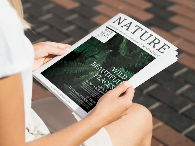 Hands holding a wild nature magazine mock up