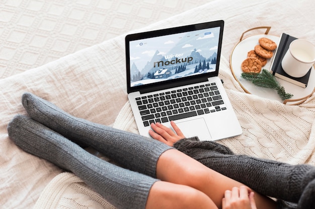 High angle woman looking at a laptop with mock-up screen Free Psd