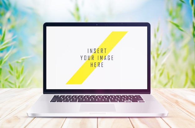 Laptop on wooden floor with plant background mock up