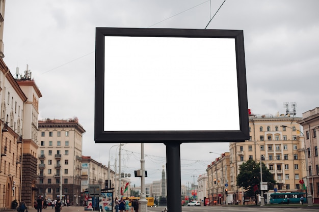Большой рекламный щит с интересной информацией и рекламой на нем установлен вдоль широкой улицы в центре города