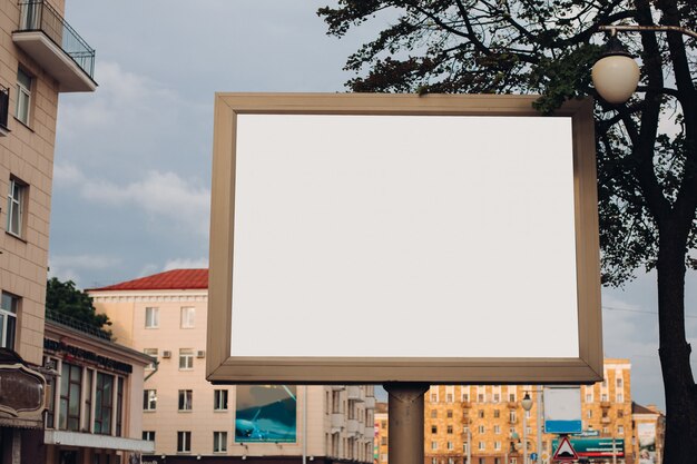 A large billboard with interesting information and advertising on it installed along a wide street in the city center