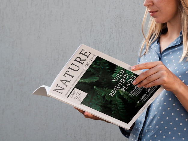 Lateral view woman holding a nature magazine