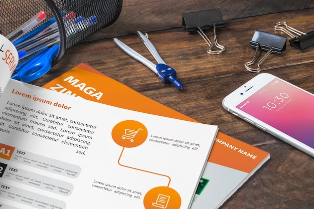 Magazine and smartphone mockup on wooden table with pens and rulers