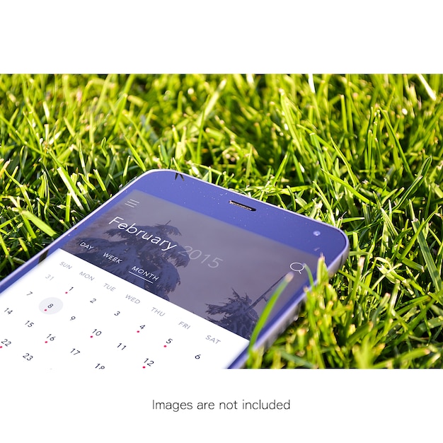 Free PSD mobile phone on grass mock up