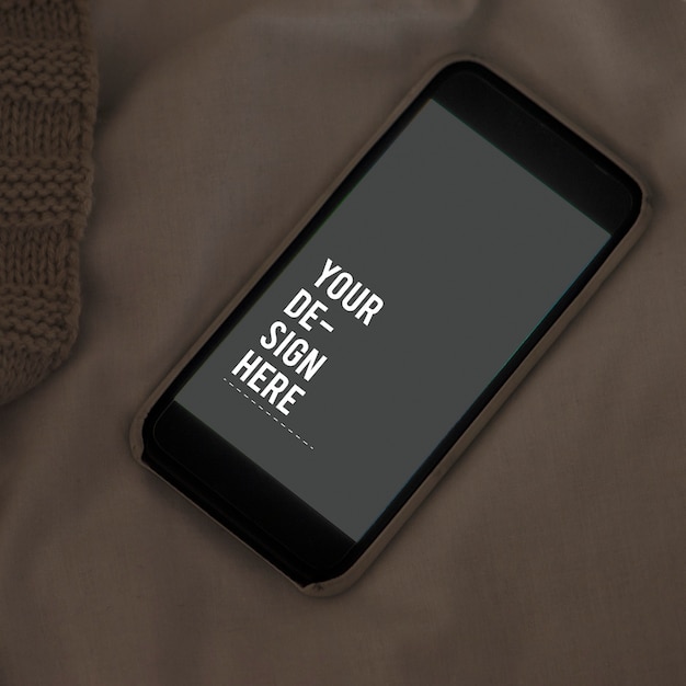 Free PSD mobile phone screen mockup on sheet surface