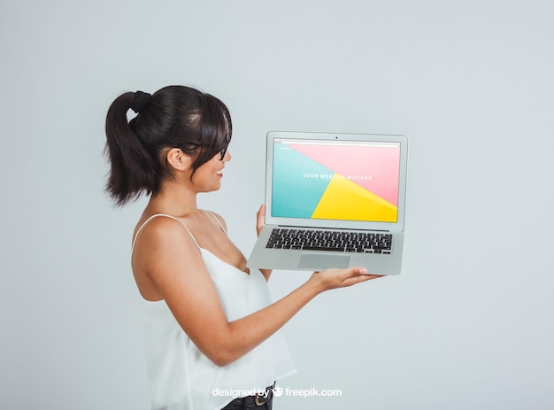 Free PSD mock up design with woman posing sideways with laptop