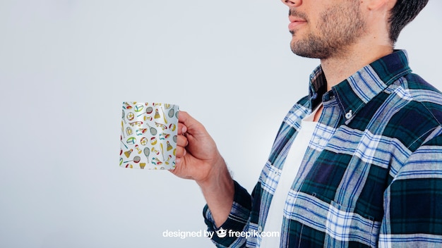 PSD gratuito mock up design con giovane ragazzo in possesso tazza di caffè