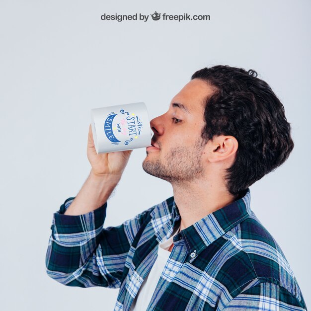 Mock up design of young mand drinking with coffee mug