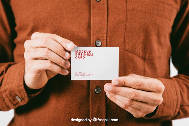 Mock up with young man's hands holding business card