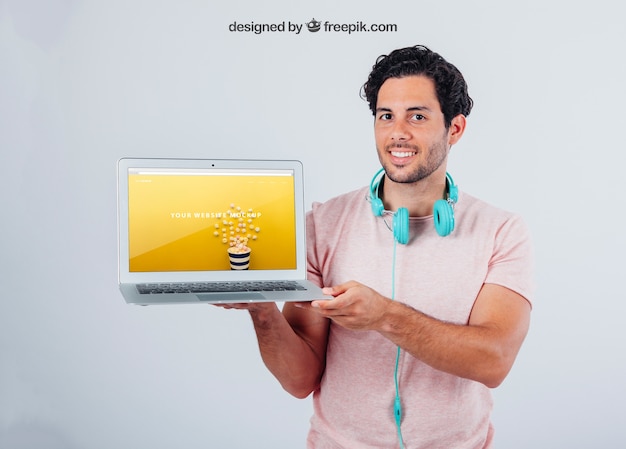 PSD gratuito moderno ragazzo con auricolari e computer portatile mock up