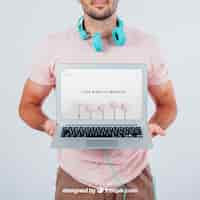 Free PSD modern young guy holding laptop's mock up