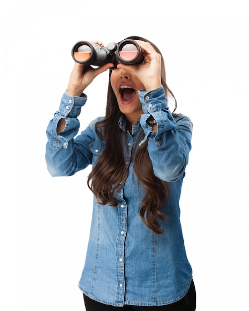 Nosy young woman with binoculars