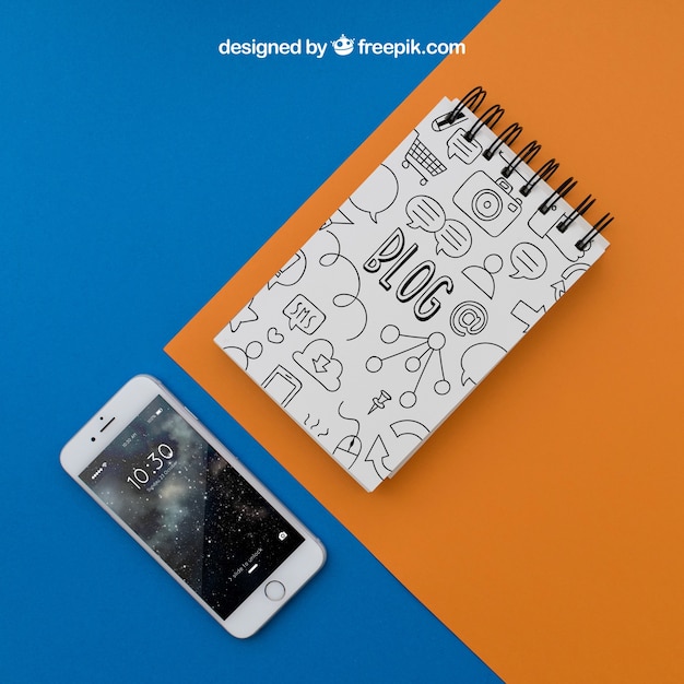 Notepad and smartphone on orange and blue background