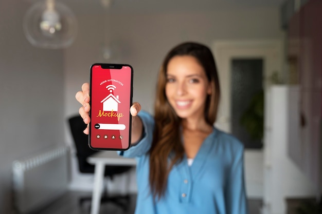 Person holding a smartphone with a home automation app