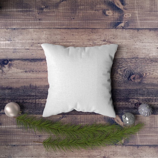 Pillow on a wooden table surrounded by baubles, pines and fir