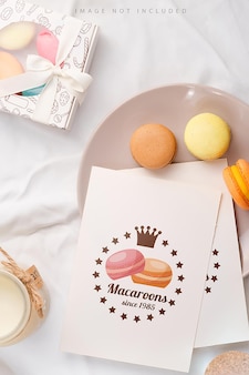 Plate with mockup paper blank and macarons on textile background