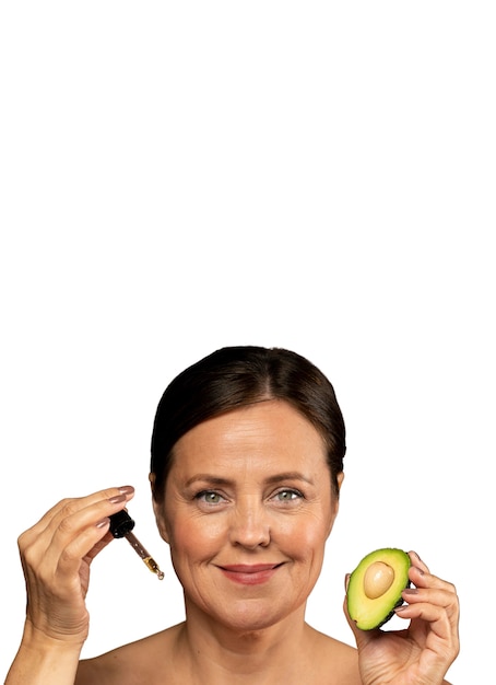 Portrait of senior woman with avocado for skincare