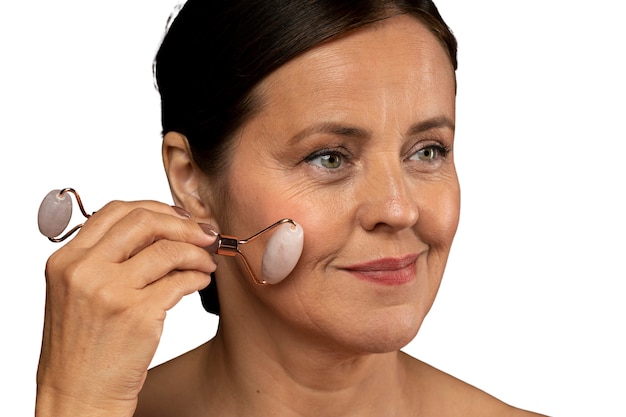 Portrait of senior woman with jade roller for skincare