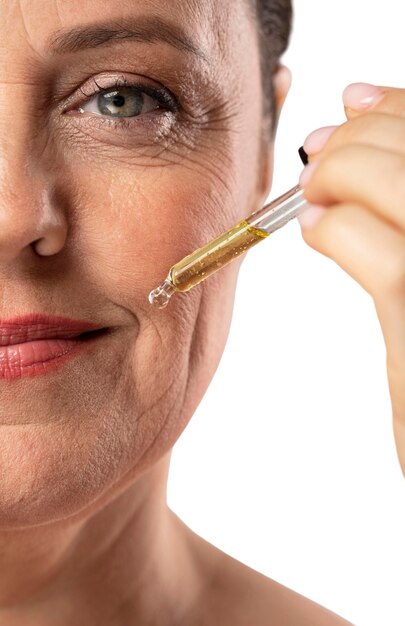 Portrait of senior woman with skin serum
