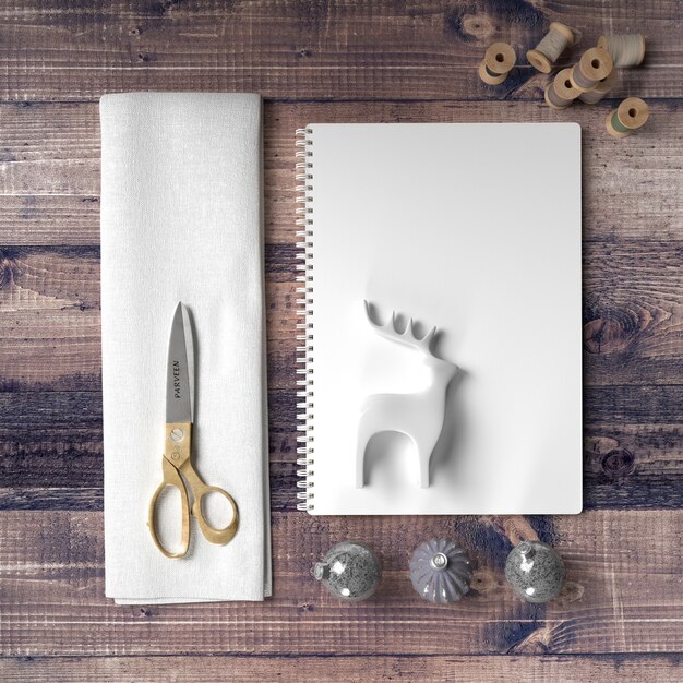 Scissors and paper to make a reindeer decoration on wooden table