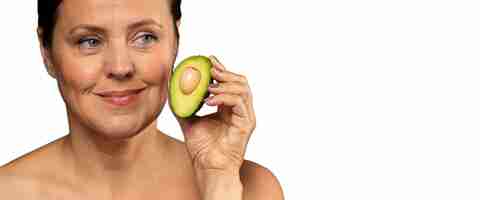 Free PSD senior woman with avocado for skincare