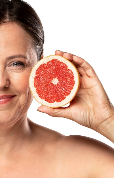 Senior woman with grapefruit for skincare